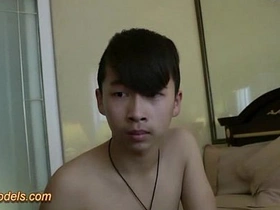 Asian guy pleasures himself on camera with a large, uncircumcised penis